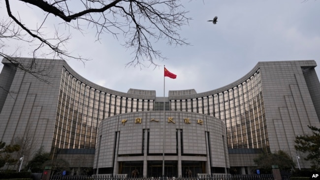 FILE - The national flag flies in front of China's central bank in Beijing, Jan. 20, 2022. Ratings agency Moody's cut its outlook on China's government credit ratings to negative from stable, Dec. 5, 2023.