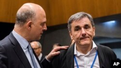 Pierre Moscovici (kiri), pejabat ekonomi Uni Eropa berbicara dengan Menkeu Yunani Euclid Tsakalotos (foto: dok). 