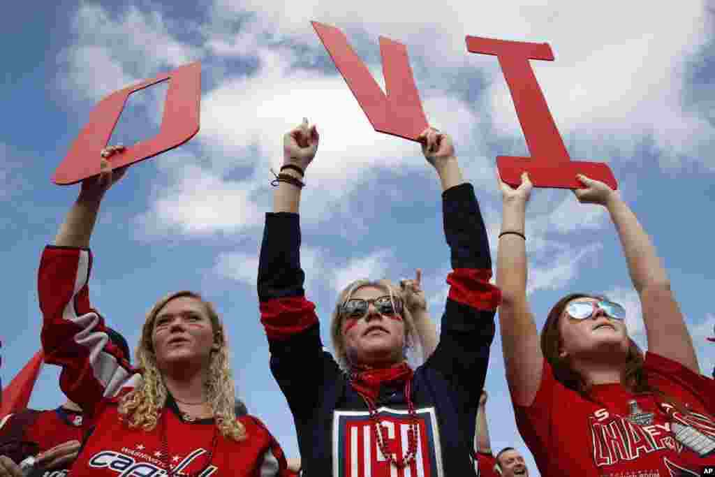 Olivia Spicer, 16, left, Emma Jacobs, 17, and Caroline Schwartz, 18, all of Gainesville, Va., hold up letters spelling the nickname of Washington Capitals&#39; left wing Alex Ovechkin, from Russia, on the National Mall ahead of a victory parade and rally for the Washington Capitals as hockey fans celebrate their winning the Stanley Cup in Washington.