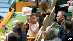 File - A young member of the Polish delegation shows off a drawing she made during the 30th anniversary of the adoption of the Convention on the Rights of the Child, Nov. 20, 2019, at United Nations headquarters.