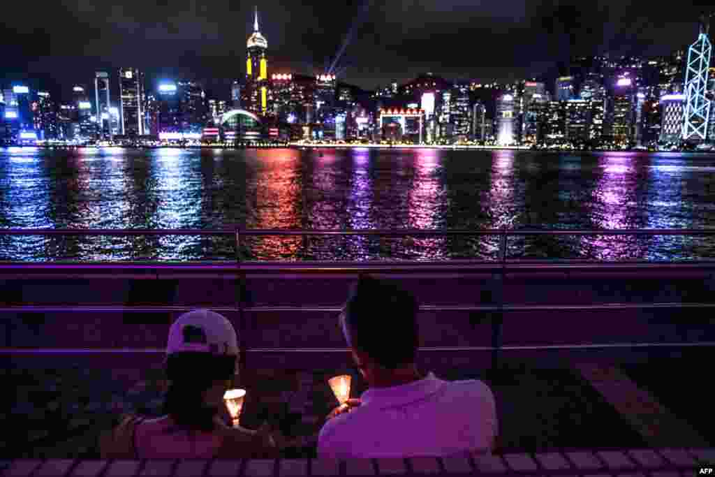 A couple hold candles along the Tsim Sha Tsui waterfront in Hong Kong, to mark the 31st anniversary of the 1989 Tiananmen Square crackdown in Beijing, China.