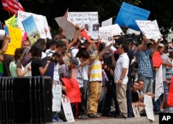 Protesters ask for help for Yazidi people who are stranded by violence in northern Iraq, Aug. 7, 2014, across from the White House in Washington.