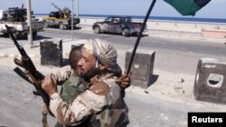 Anti-Gaddafi fighters embrace as they celebrate the fall of Muammar Gaddafi in Sirte October 20, 2011. Gaddafi was killed by Libyans he once scorned as "rats", succumbing to wounds, some seemingly inflicted after his capture by fighters who overran his la