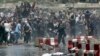 Protesters throw stones toward security forces during a demonstration in Kabul, Afghanistan, Friday, June 2, 2017.