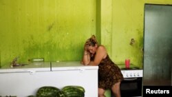 ARCHIVO- Una mujer venezolana descansa en la cocina de un gimnasio convertido en refugio de la Defensa Civil para venezolanos, donde iglesias evangélicas proveen comidas, en el barrio de Caimbe, Boa Vista, estado de Roraima, Brasil. Foto del 17 de noviembre de 2017. REUTERS/Nacho Doce.