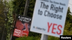 Anti-abortion-rights and pro-abortion-rights posters are seen outside the home of Amy Callahan, who received a fatal fetal diagnosis at 12 weeks into her pregnancy and traveled to Liverpool for a termination in Dublin, Ireland, May 7, 2018. Ireland will vote this month on whether to retain a constitutional ban on abortions or repeal it and make parliament responsible for creating abortion laws.