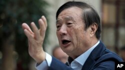 FILE - Ren Zhengfei, founder and CEO of Huawei, gestures during a meeting with reporters in Shenzhen city, south China's Guangdong province, Jan. 15, 2019. 