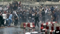 Protesters throw stones toward security forces during a demonstration in Kabul, Afghanistan, Friday, June 2, 2017.