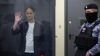 Nhà báo Evan Gershkovich của Wall Street Journal, người đang bị giam giữ vì tội gián điệp, vẫy tay sau bức tường kính dành cho các bị cáo khi tham dự phiên tòa ở Moscow, Nga, ngày 23/4/2024.