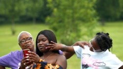 Zakia Buchanan, center, shows TikTok videos to her mom, Delicia Harris, left, as her youngest sister Antoinette Harris, touches her face, July 22, 2021 at Rock Cut State Park in Loves Park, Ill.