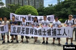 2018年8月6日，人们在中国广东省深圳市坪山区燕子岭派出所外示威，手持标语，支持佳士工厂工人。