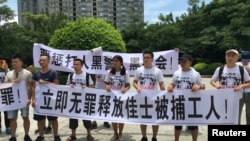 2018年8月6日，人们在中国广东省深圳市坪山区燕子岭派出所外示威，手持标语，支持佳士工厂工人。