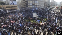 Demonstrators carry flags during a ‘day of rage’ to protest at a major square in the northern port city of Tripoli, Lebanon, January 25, 2011