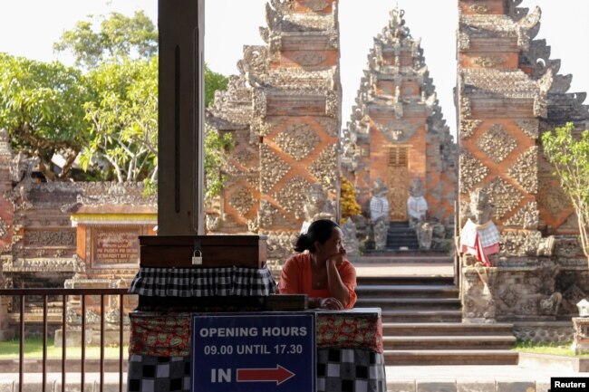 Seorang perempuan menunggu para wisatawan di Pura Puseh, Desa Batuan, Gianyar, Bali, 5 Februari 2020. (Foto: Reuters)