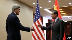 U.S. Secretary of State John Kerry, left, prepares to shake hands with Chinese Foreign Minister Wang Yi at the Ministry of Foreign Affairs in Beijing, Jan. 27, 2016.