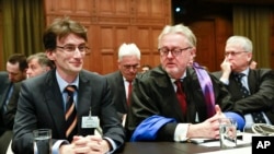 FILE - Members of the Serbian delegation, First Counsellor Sasa Obradovic, left, William Schabas, center and Andreas Zimmermann, right, await the start of public hearings at the International Court of Justice (ICJ) in The Hague, Netherlands, March 3, 201