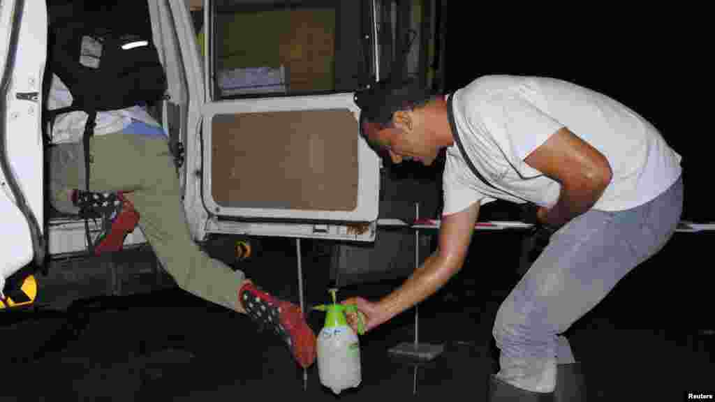 Un travailleur de l&#39;ONG international Médecins Sans Frontières pulvérise les bottes de son collègue avec un désinfectant au chlore pour prévenir Ebola à Monrovia, Liberia, le 20 ocotbre 2014. REUTERS/James Giahyue 