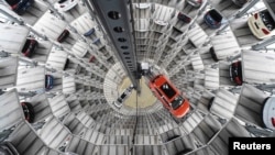 FILE - A VW Golf VII car (R) and a VW Passat are loaded in a delivery tower at the plant of German carmaker Volkswagen in Wolfsburg, March 3, 2015.