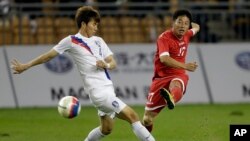 지난 2013년 10월 중국 톈진에서 열린 동아시아 6개국 축구대회 북한과 한국의 경기에서 북한 리혁철(오른쪽)이 한국 최영광의 수비를 뚫고 슛을 하고 있다. (자료사진)