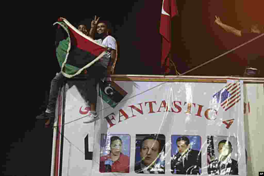 People celebrate the recent news of uprising in Tripoli against Moammar Gadhafi's regime in the rebel-held town of Benghazi, Libya, Aug. 21, 2011. (AP)