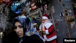 A woman walks past by a store selling New Year and Christmas ornaments in Istanbul, Turkey, Dec. 22, 2015. Turkey on Wednesday detained two suspected Islamic State members believed to be planning suicide attacks on New Year's celebrations in the country's capital.