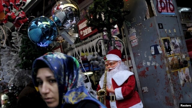 Una mujer en Ankara, Turquía, pasa frente a una tienda que vende adornos de Navidad y Año Nuevo. Dos sospechosos fueron arrestados por las autoridades turcas, acusados de planear ataques suicidas en Ankara.