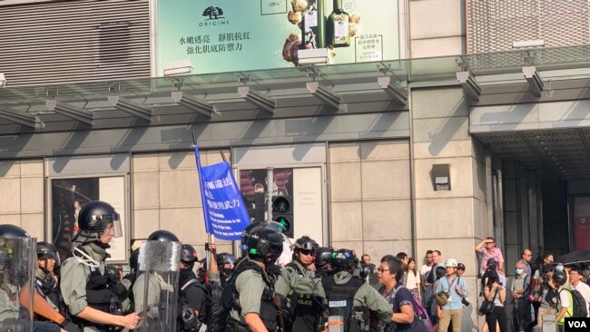 10月27日,一名女士在抗议现场与港警对话(美国之音李逸华拍摄)