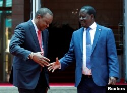 Kenya's President Uhuru Kenyatta, left, shakes hands with opposition leader Raila Odinga of the National Super Alliance coalition following a joint news conference at the Harambee house office in Nairobi, Kenya, March 9, 2018.