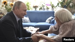 Russia's President Vladimir Putin congratulates the head of the Moscow Helsinki Group, Lyudmila Alekseyeva, on her 90th birthday during a meeting in Moscow, July 20, 2017. 