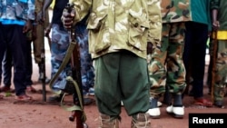 FILE - A former child soldier poses with his gun in this undated photo.
