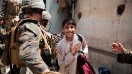 In this photo provided by the U.S. Marine Corps, a boy is processed through an Evacuee Control Checkpoint during an evacuation at Hamid Karzai International Airport, in Kabul, Afghanistan, Wednesday, Aug. 18, 2021.