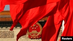 The Great Hall of the People is seen behind red flags in Tiananmen Square in Beijing, Nov. 12, 2013.