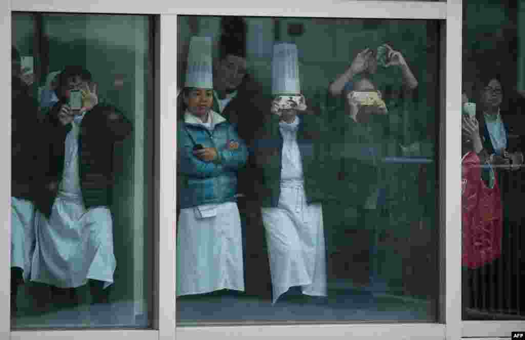 People take pictures through a window as they wait to see Britain&#39;s Prince William in Shanghai, China.