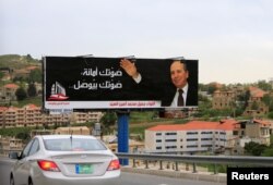 A car drives past a campaign poster for Jamil al-Sayyed at Dahr al-Baidar area in Lebanon's eastern Bekaa Valley, April 25, 2018.
