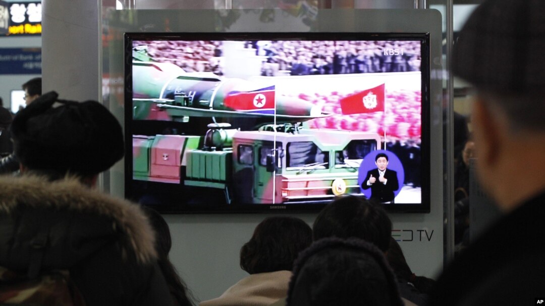 People watch a TV news showing file footage of a North Korean rocket carried during a military parade, at Seoul Railway Station in Seoul, South Korea, January 24, 2013.