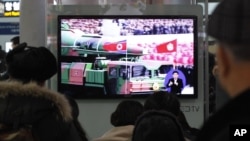 People watch a TV news showing file footage of a North Korean rocket carried during a military parade, at Seoul Railway Station in Seoul, South Korea, January 24, 2013.