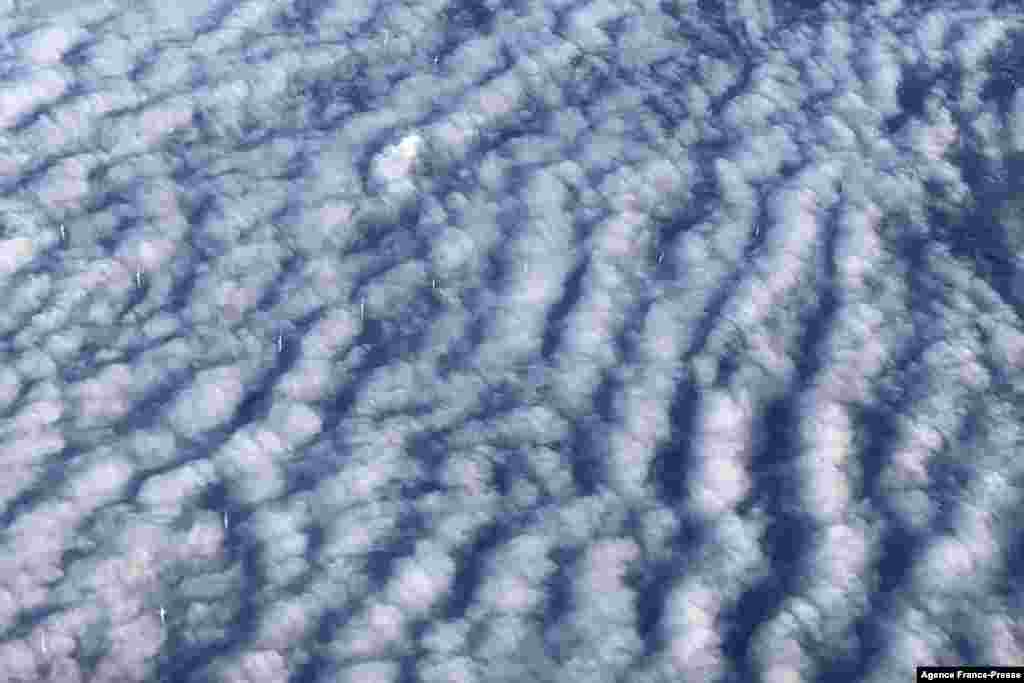 This picture taken from a plane shows wind turbines through stratocumulus clouds over Germany.