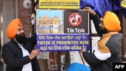 Tình nguyện viên treo bảng "Tik Tok bị cấm ở đây" tại đền thờ ở Amritsar, Ấn Độ.