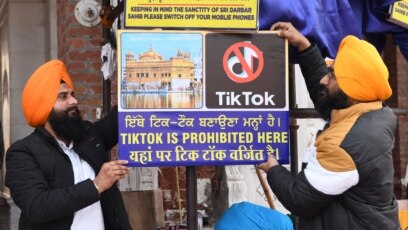 Tình nguyện viên treo bảng "Tik Tok bị cấm ở đây" tại đền thờ ở Amritsar, Ấn Độ.