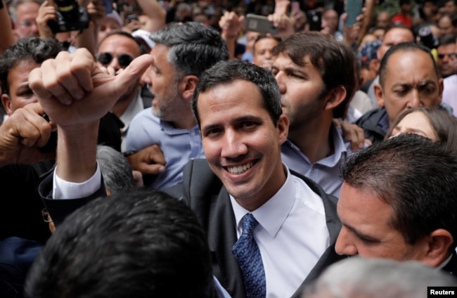 Pemimpin oposisi Venezuela, Juan Guaido dikelilingi para pendukungnya sebelum mengadakan konferensi pers di Caracas, Jumat (25/1).