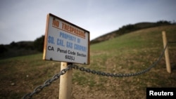 FILE - A gas company sign marks a fence near the site of the Aliso Canyon storage field where gas has been leaking in Porter Ranch, California, Jan. 21, 2016. 