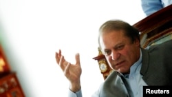 Nawaz Sharif, the leader of Pakistan Muslim League - Nawaz (PML-N), gestures as he speaks to foreign reporters at his residence in Lahore May 13, 2013. 