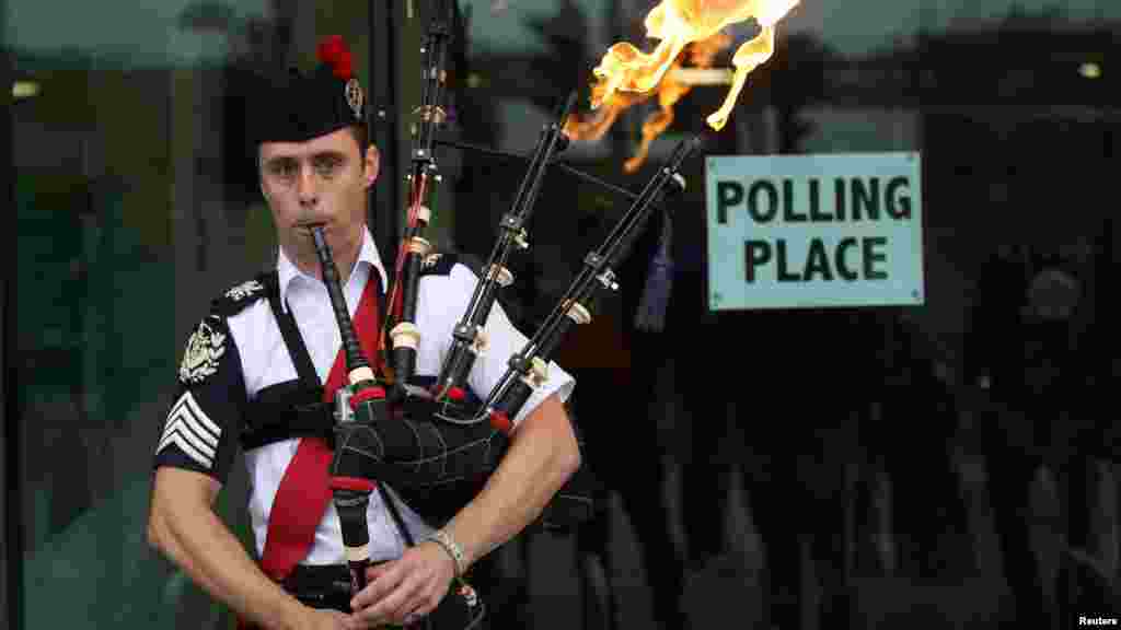 Ryan Randall plays the bagpipes outside a polling station in Edinburgh, Scotland, Sept. 18, 2014.