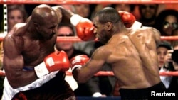 Challenger Mike Tyson (R) and WBA Heavyweight Champion Evander Holyfield mix it up during round one action at the MGM Grand on June 28. Tyson was disqualified in the third round for biting Holyfield on the ear. **DIGITAL IMAGE** - PBEAHUMNKAO