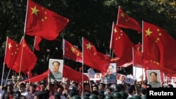 中国示威者手举毛泽东象、国旗和标语在北京日本使馆外抗议游行