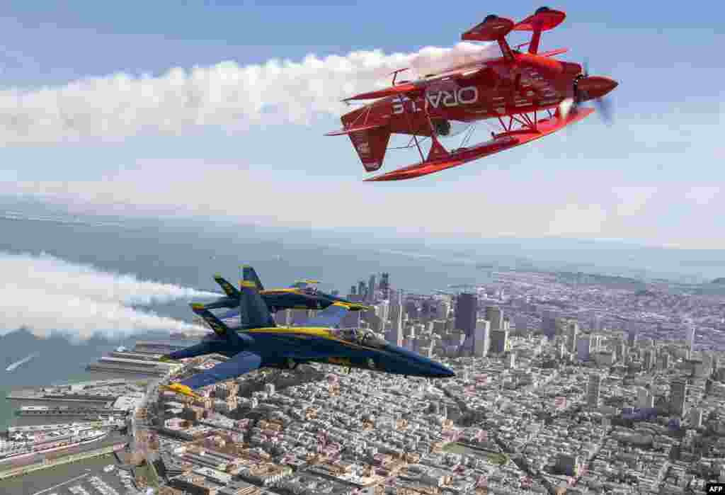 The U.S. Navy Blue Angels numbers 5 and 6 fly below Sean Tucker (above) as he pilots the Oracle Challenger III over San Francisco, California as part of a practice run for Fleet Week, Oct. 6, 2016.
