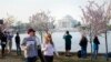 Tourists and visitors line up along the edge of the Tidal Basin to photograph the cherry blossom during in early morning, Washington, DC, April 14, 2014. (Elizabeth Pfotzer/VOA)