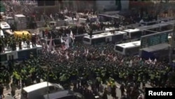 Police surround demonstrators during a protest in front of the Constitutional Court in Seoul, South Korea, in this image from video, March 10, 2017.