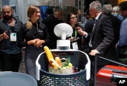 The Cloi shopping cart robot, center, appears on display at the LG booth during CES International, Jan. 9, 2018, in Las Vegas.