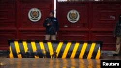 FILE - A policeman stands guard outside the Khyber Pakhtunkhwa House, where negotiations took place between Pakistani government officials and Taliban negotiators, in Islamabad, February 6, 2014.